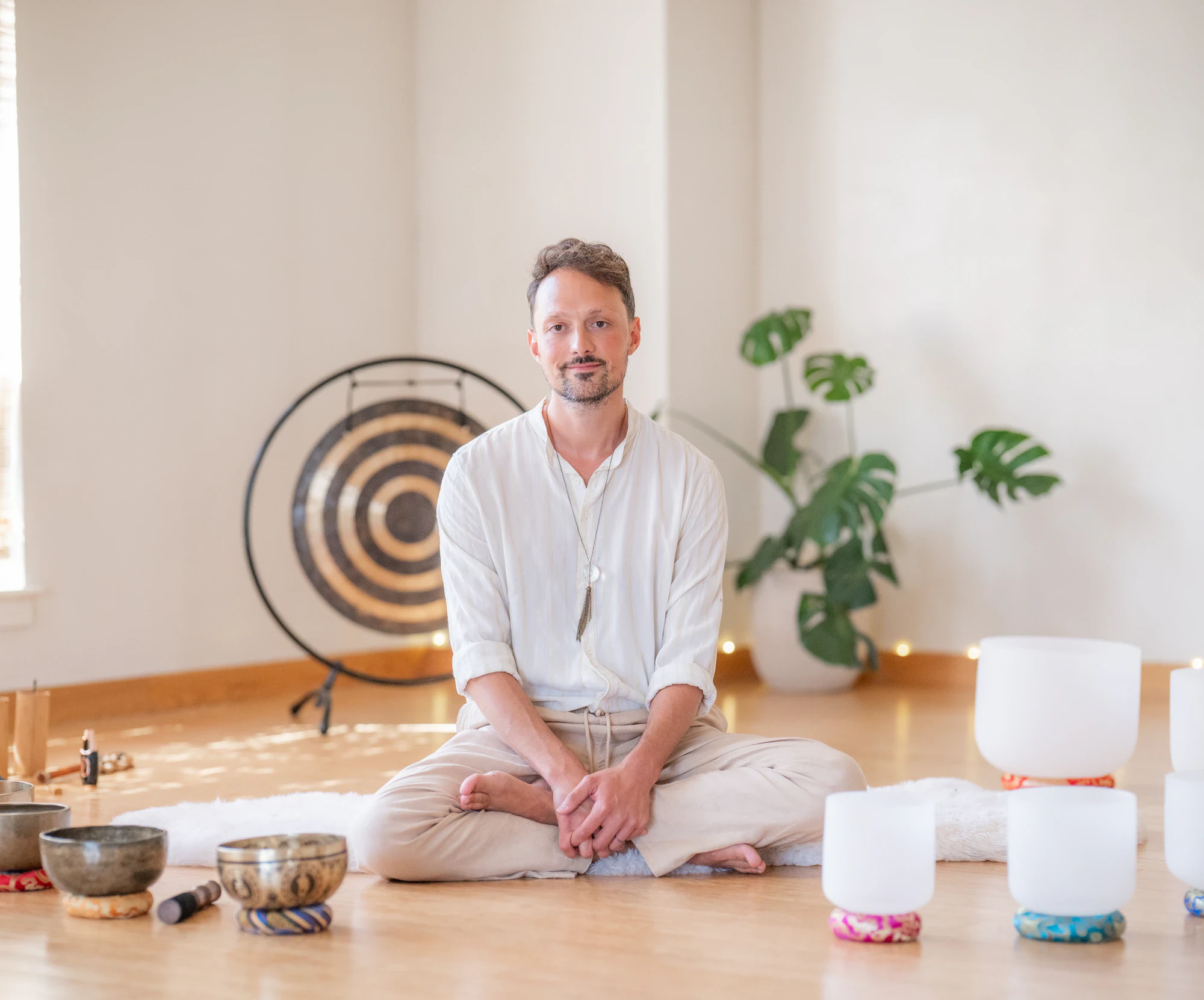 Matias Seijas sitting cross-legged surrounded by singing bowls